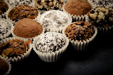 Round homemade chocolates in different kind of decor on paper su