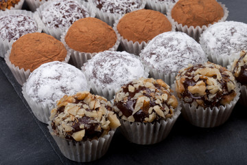 Round homemade chocolates in different kind of decor on paper su