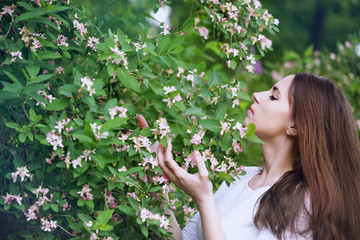 Woman smelling a flower honeysuckle