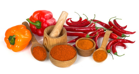 paprika and chili powder ground in a wooden bowl and spoon on wh