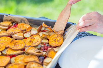 Woman's Hand takes Roasted Vegetables, Close-up View, Summertime