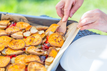 Woman's Hand takes Roasted Vegetables, Close-up View, Summertime