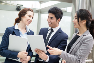 Group of business people discuss on tablet pc
