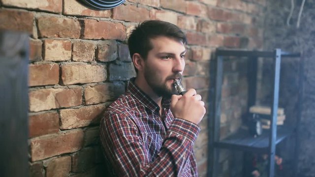Handsome man Exhaling smoke from a vaporizer shot