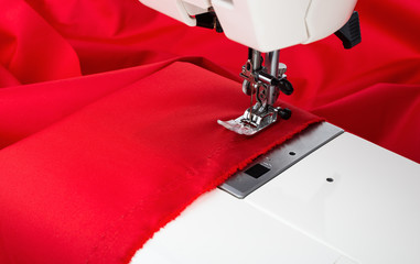 Sewing machine and red fabric isolated on white