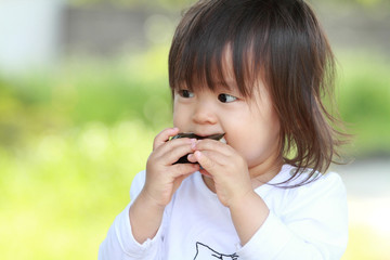 おにぎりを食べる幼児(1歳児)