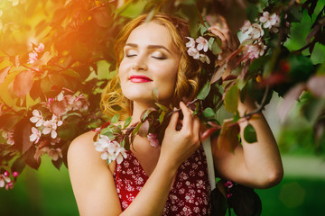Fototapeta premium A young girl in an Apple orchard at sunset