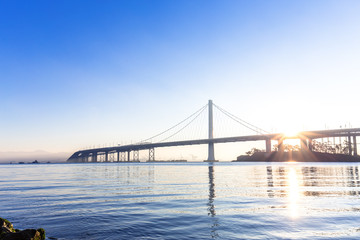 tranquil water and gold gate bridge at sunrise