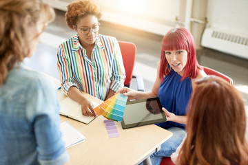 Unposed group of creative business people in an open concept office brainstorming their next project.