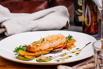 baked salmon with vegetables on glass plate isolated. Restaurant