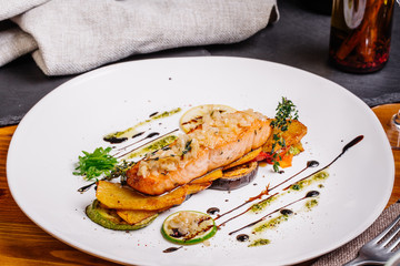 baked salmon with vegetables on glass plate isolated. Restaurant