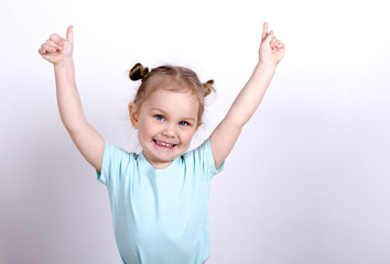 little girl in a blue t-shirt raised her hands up and smiling, blonde