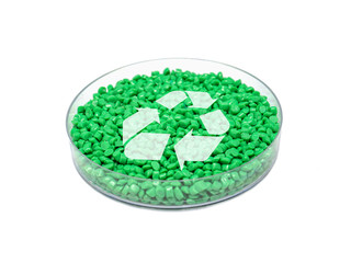 Grünes PET-Granulat in Petrischale mit Recycling-Symbol (Rohstoff; Recycling; Umwelt)

