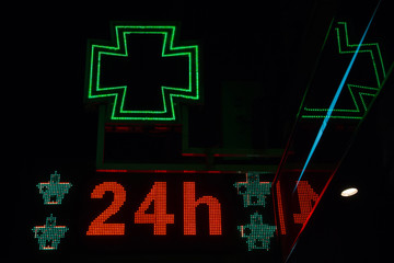  Nocturno de letrero luminoso de farmacia encendido. Con el mensaje de abierto las 24 horas del día
