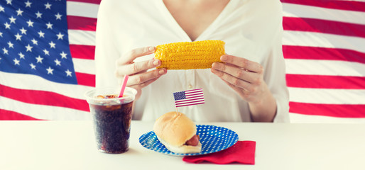 woman hands holding corn with hot dog and cola