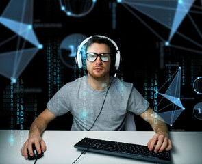man in headset hacking computer or programming