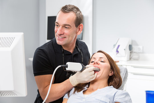 Dentist scanning patient's teeth with a CEREC scanner