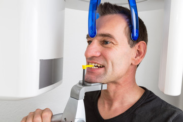 Patient in dentist's panoramic and cephalometric x-ray system