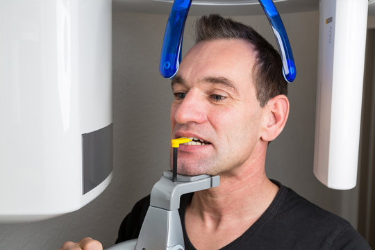 Patient in dentist's panoramic and cephalometric x-ray system