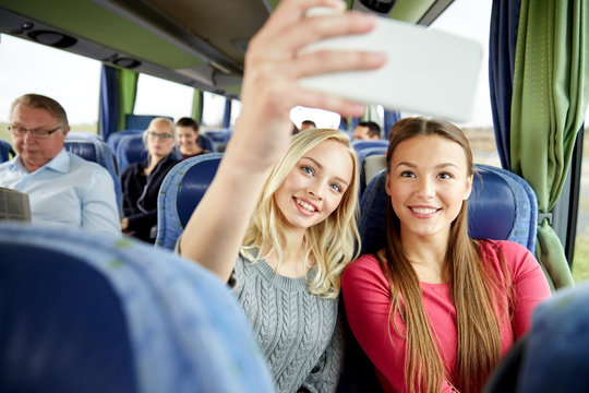 women taking selfie by smartphone in travel bus