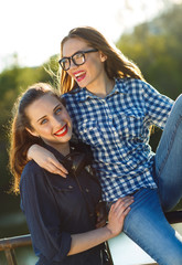 Fototapeta premium Two playful young girl having fun outdoors at sunset light