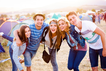 Group of teenagers at summer music festival, sunny day
