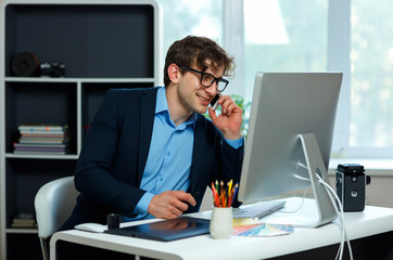 Naklejka premium Handsome young man working from home office and using smartphone