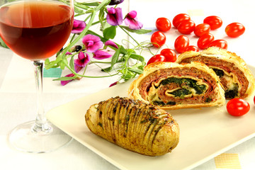 Two slices of meatloaf crust, an Hasselback tomato and flower.