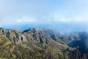 Obraz premium Barranco de Benchijigua on the Canary island La Gomera in clouds, which were formed above regions within trade wind. The clouds comes from the Azores and reaches the Islands in approx. 800m altitude