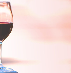 Glass of red wine in pink background