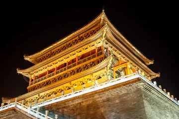 Selbstklebende Fototapeten The illuminated ancient Drum Tower located at the ancient city wall by night time, Xian, Shanxi Province, China © MediaNation.online