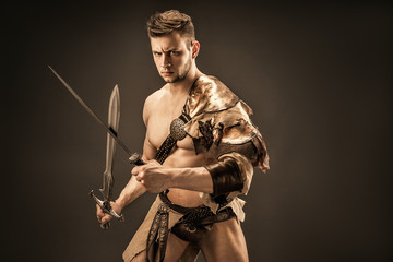 Portrait of angry warrior in leather clothes with swords