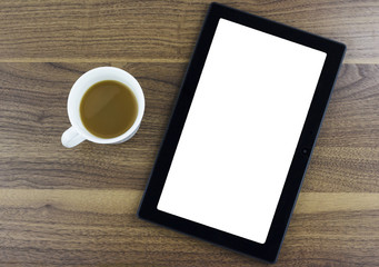 Fototapeta na wymiar Tablet with blank screen sitting next to a cup of coffee