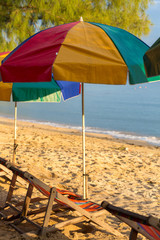 Beach chairs and colorful umbrellas on the beach in sunny day, T