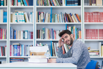 portrait of student while reading book  in school library