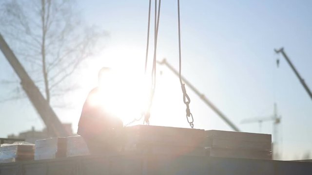 Builder puts on building bricks crane