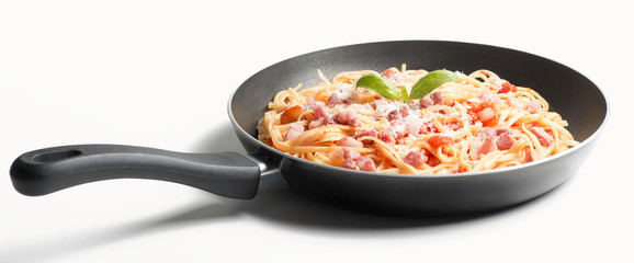 Spaghetti with amatriciana sauce in the pot on the wooden table