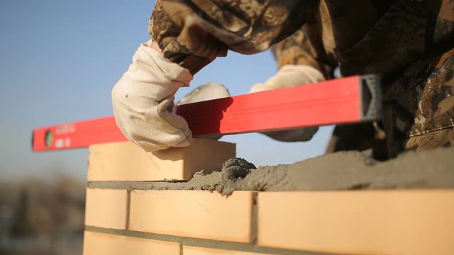 bricklayer laying bricks to make a wall 4