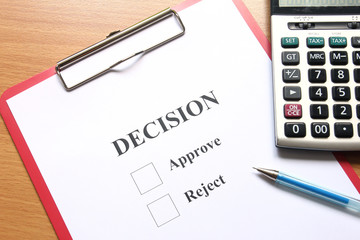 Decision paper and calculator on wooden table