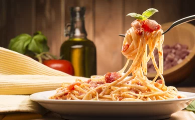 Papier Peint photo Manger spaghettis à la sauce amatriciana dans le plat sur la table en bois