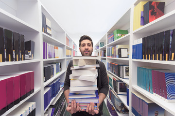 Student holding lot of books in school library