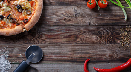 Tasty pizza with ingridients on a wooden board.
