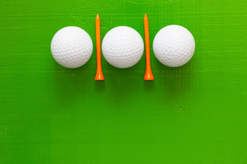 Golf balls and wooden golf tees on the green table
