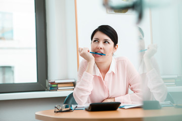 Young office worker dreaming in her workplace