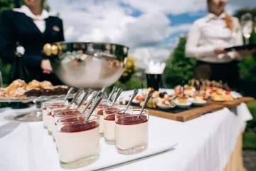 Tuinposter catering services in restaurant outdoor on wedding ceremony in the park. Food and glass of champagne © Yevhenii Kukulka