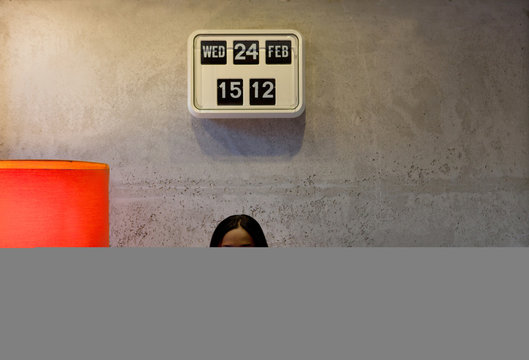 Woman underneath flip clock looking at camera