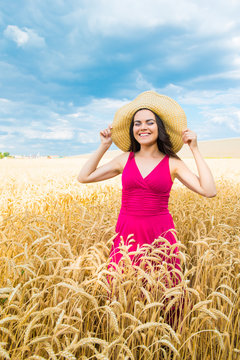 young woman in a wheat field hat