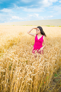 young woman in the field, looking into the distanc