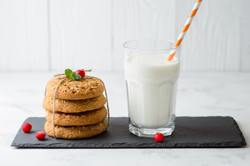 Oatmeal cookies with glass of milk on a white background