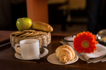 Morning breakfast in the bed. Coffee, newspaper and croissant